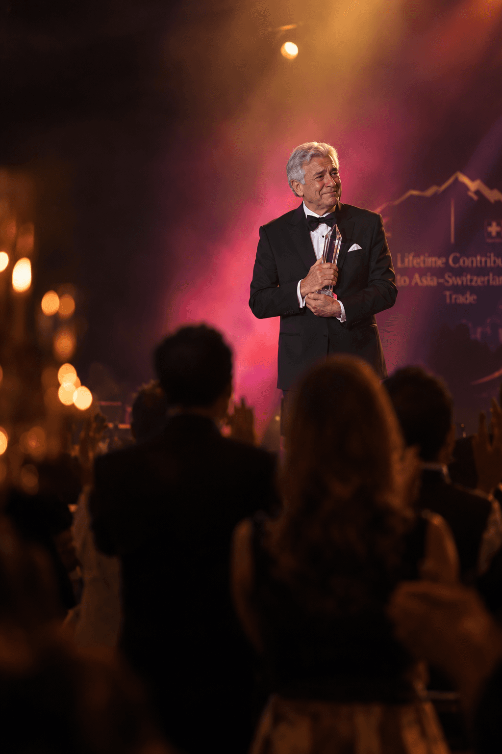 A business leader holding a crystal award on stage as the audience rises in applause