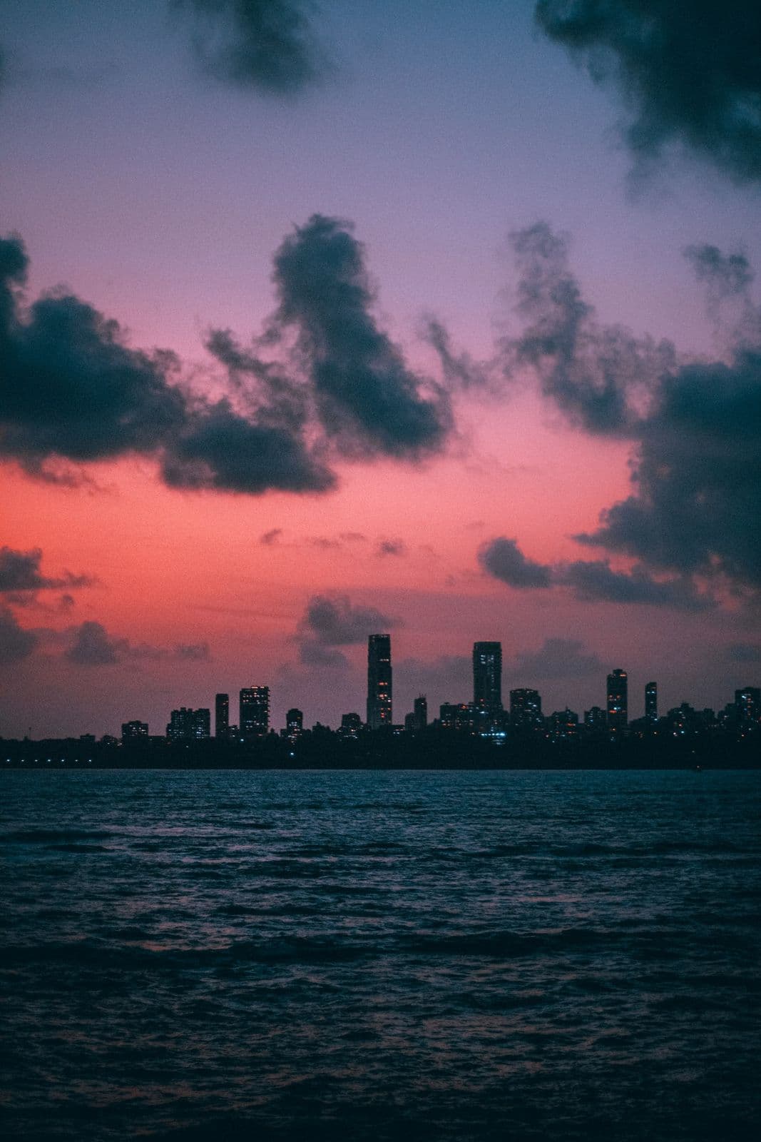 Mumbai's skyline across the water at sunset