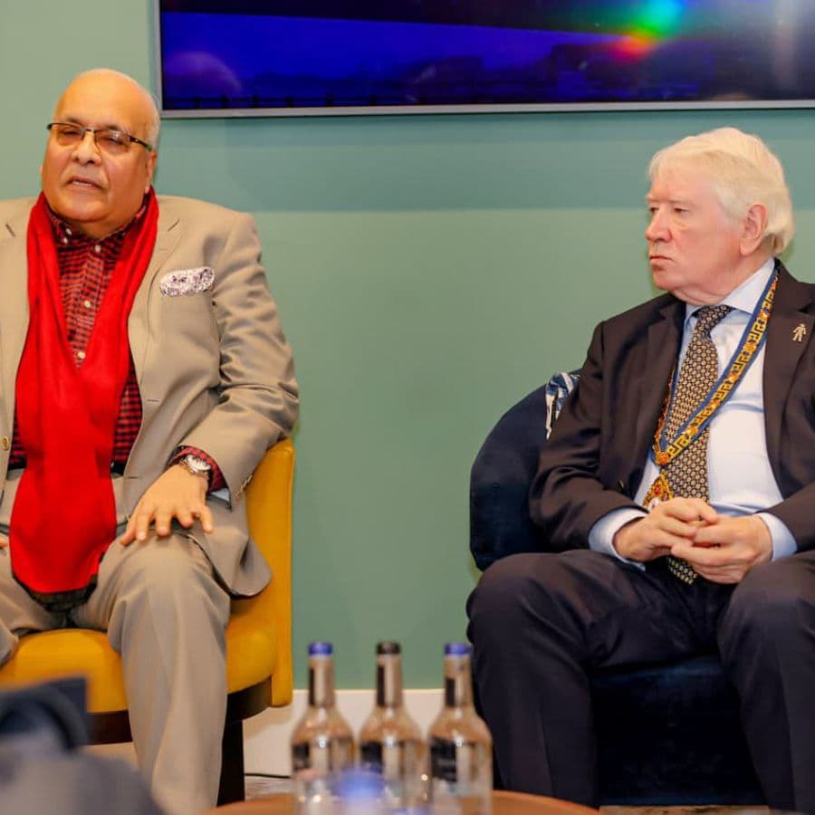 Two speakers in armchairs during a panel conversation