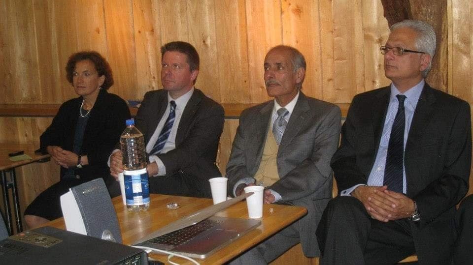 Four panellists seated at a table during a summit session