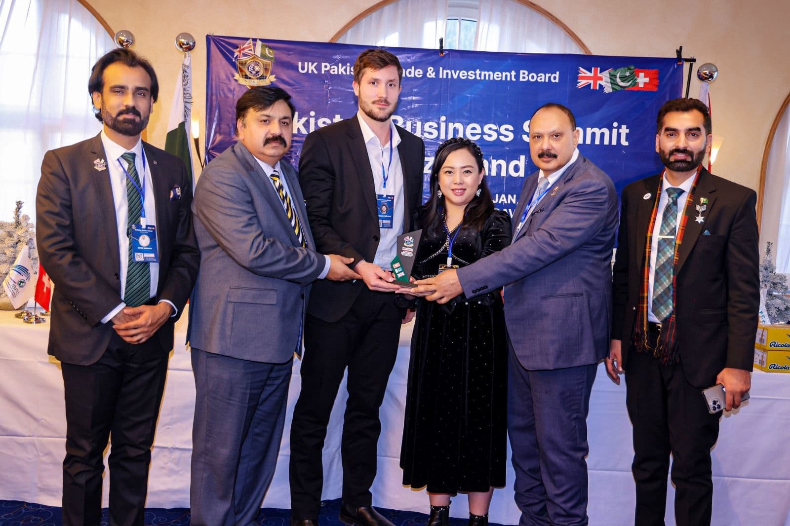 An honoree holding her award with the presenters at the organisers' previous summit