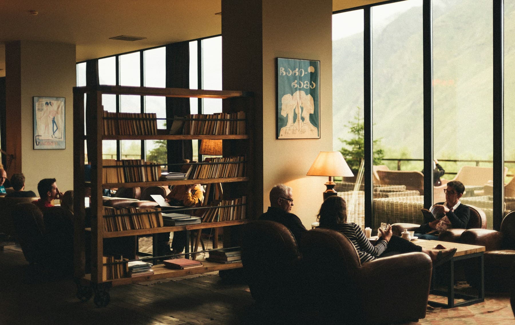 Guests talking in a warm lounge with a mountain view