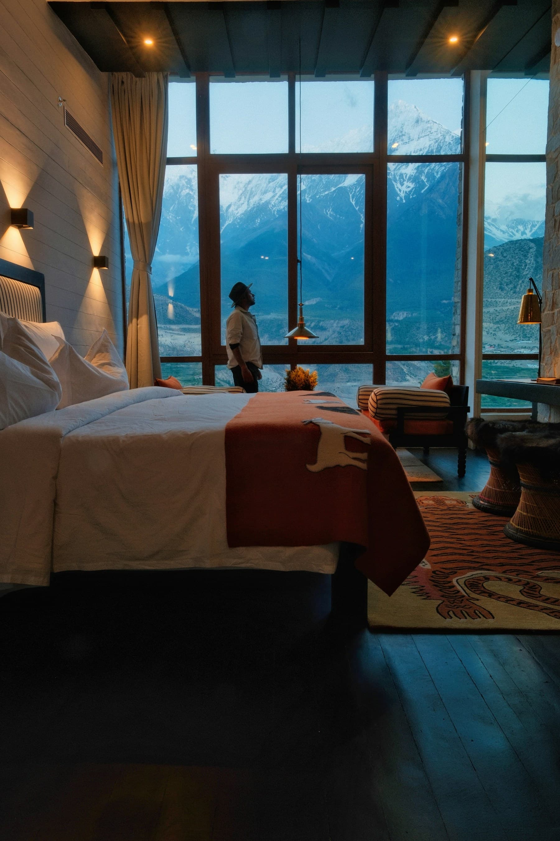 A guest looking out at snowy peaks from a hotel room