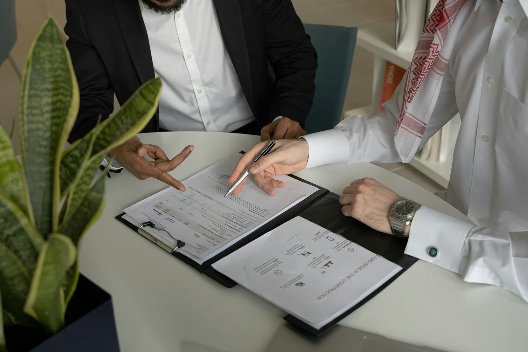 Two businessmen going through documents with a pen