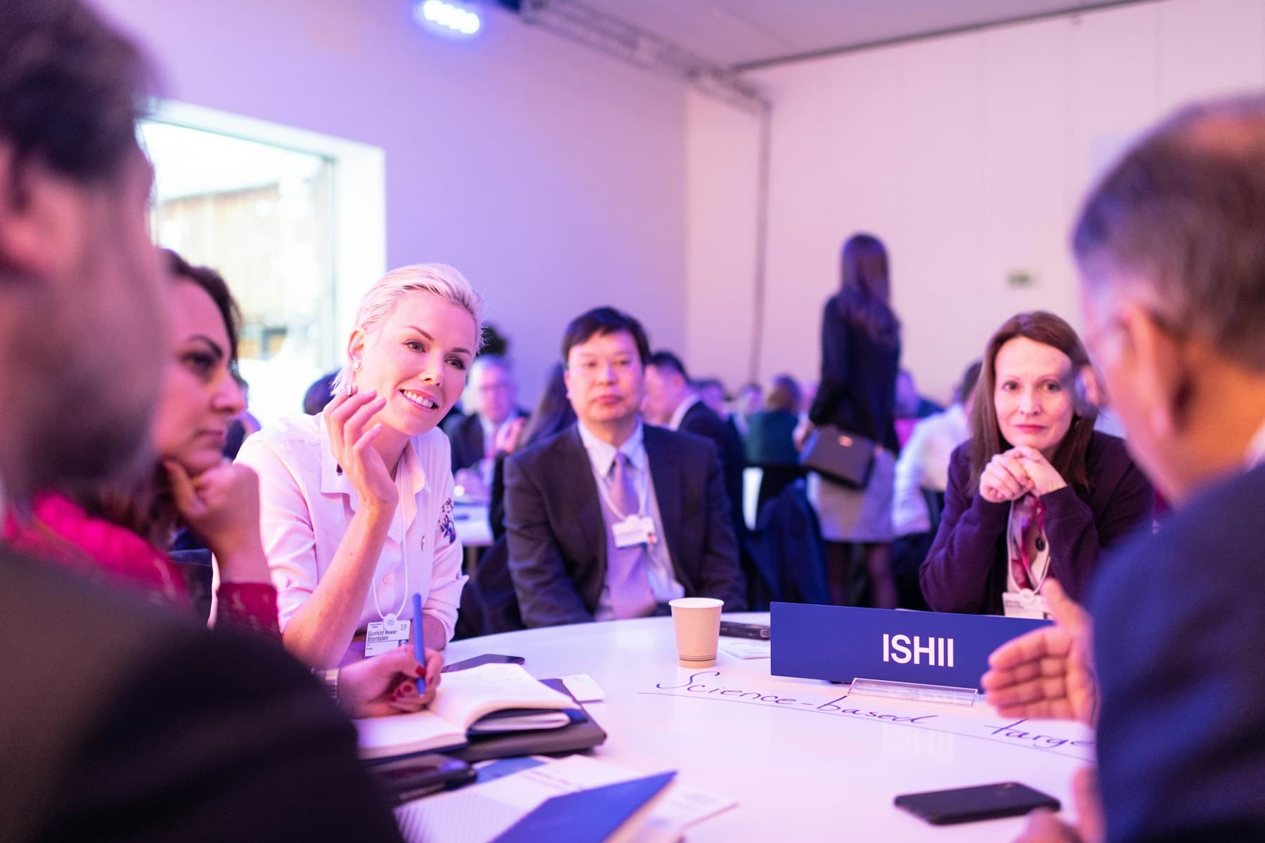 Delegates in conversation around a table at a business event