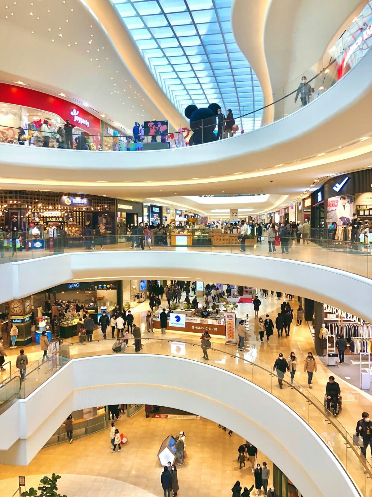 Shoppers on the curved floors of a shopping mall atrium