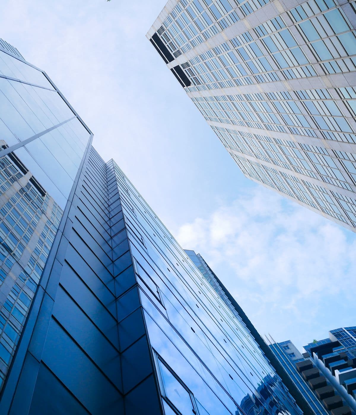 Glass office towers rising against a blue sky