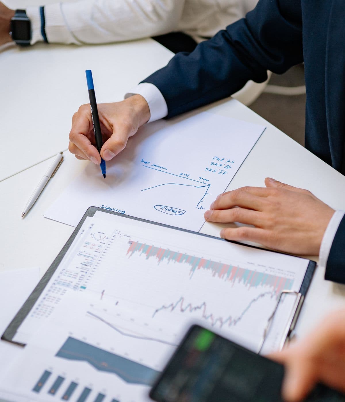 An investor reviewing charts on a printed report, pen in hand